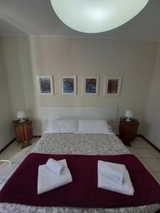 una camera da letto con un letto con due asciugamani bianchi di Appartamento al Battistero a Oggiono