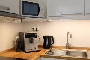 a kitchen counter with a coffee maker and a microwave at Ferienwohnung Alpenglück hoch3 in Oy-Mittelberg