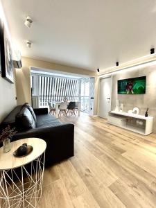 a living room with a black couch and a table at Apartamento Salou Playa Jaime I in Salou