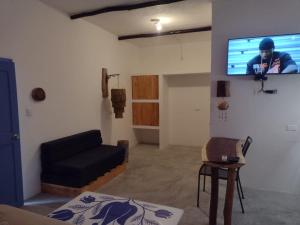 a living room with a couch and a flat screen tv at MIO Tulum Hotel Boutique in Tulum