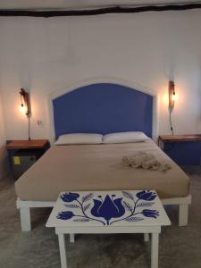 a bedroom with a large bed with a blue headboard at MIO Tulum Hotel Boutique in Tulum