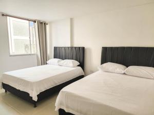 dos camas sentadas una al lado de la otra en un dormitorio en Apartamento 3 habitaciones Palanoa Rodadero - By Bedviajes, en Santa Marta