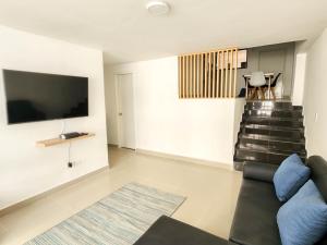 sala de estar con sofá y TV en Apartamento 3 habitaciones Palanoa Rodadero - By Bedviajes, en Santa Marta
