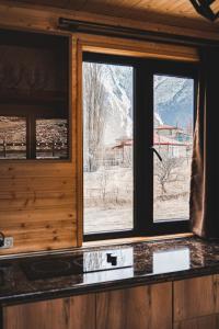 a kitchen window with a view of a snowy mountain at Cottages LIZA in Stepantsminda
