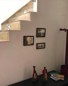 um quarto com uma escada com três fotografias na parede em Casa vacanze Ni Micheli em Naro