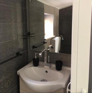 ein Badezimmer mit einem Waschbecken mit zwei schwarzen Tassen darauf in der Unterkunft Casa vacanze Ni Micheli in Naro