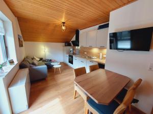 eine Küche und ein Wohnzimmer mit einem Sofa und einem Tisch in der Unterkunft Ferienhaus "Anne" und Weingut Willi Fett in Ellenz-Poltersdorf