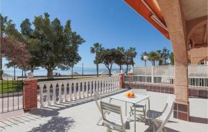 un tavolo e sedie su un patio con vista sull'oceano sullo sfondo di Cozy Home In Los Alczares With Kitchen a Los Narejos