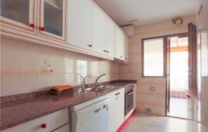 una cucina con armadi bianchi e lavandino di Cozy Home In Los Alczares With Kitchen a Los Narejos