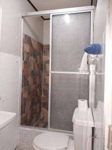 y baño con ducha, aseo y lavamanos. en Apartamento AMUEBLADO en Canoas