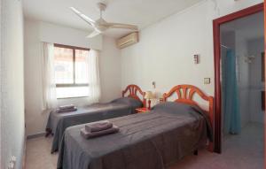 una camera con 2 letti e un ventilatore a soffitto di Cozy Home In Los Alczares With Kitchen a Los Narejos