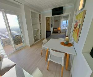 sala de estar con mesa y sillas en una habitación en Alicante Skylights Apartments, en Alicante