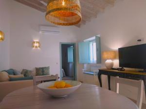 una habitación con una mesa con un tazón de naranjas. en Casa 16, en Tavira