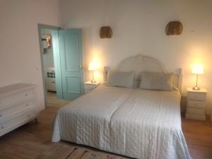1 dormitorio con 1 cama blanca y 2 lámparas en Casa 16 en Tavira