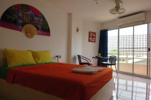 a bedroom with a bed and a large window at View Talay 1B Serviced Apartments in Pattaya South