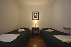 Habitación con 2 camas y mesa con lámpara. en Chalet Tres Mares, Cala Millor, en Son Servera