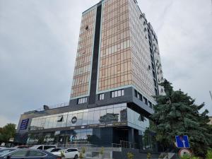 Un grand bâtiment avec des voitures garées devant lui dans l'établissement Ismail Ultracentral Deluxe Apartaments, à Chişinău