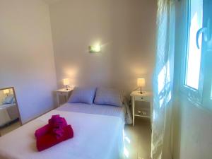 ein Schlafzimmer mit einem Bett mit einer rosa Schleife darauf in der Unterkunft Apartamento 11. Arena y mar in Playa Honda