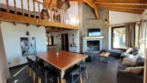 a living room with a wooden table and a fireplace at Casa Cerro Dorado vista al lago in San Carlos de Bariloche