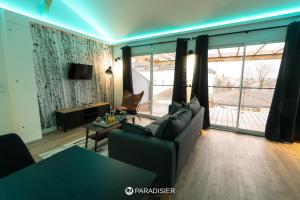 a living room with a couch and a large window at Paradisier in Villars-les-Dombes