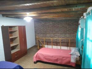 1 dormitorio con cama y pared de ladrillo en El salto en San Rafael