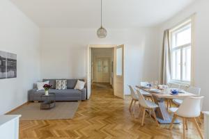uma sala de estar com uma mesa e um sofá em Grand Viennese Residence em Viena