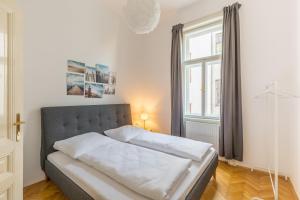 uma cama num quarto com uma grande janela em Grand Viennese Residence em Viena