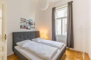 ein Bett in einem Schlafzimmer mit einem großen Fenster in der Unterkunft Grand Viennese Residence in Wien