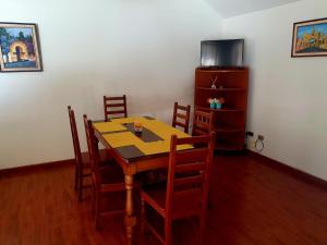 uma sala de jantar com uma mesa de madeira e cadeiras em Executive Airport Apartment Guatemala em Guatemala