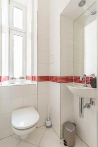 ein weißes Badezimmer mit Toilette und Waschbecken in der Unterkunft Grand Viennese Residence in Wien