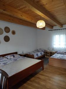 a bedroom with two beds and a wooden ceiling at Sobe Ivan Rastoke 21 in Slunj