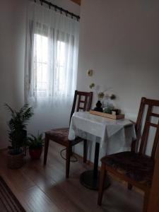 um quarto com uma mesa e duas cadeiras e uma janela em Sobe Ivan Rastoke 21 em Slunj