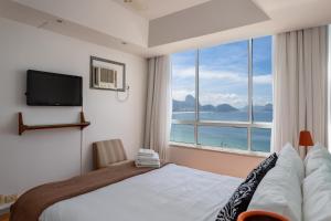 1 dormitorio con cama y ventana grande en Belíssimo em Copacabana - Vista para o mar - A1103 Z3, en Río de Janeiro