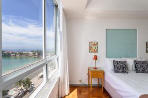 1 dormitorio con ventana grande con vistas al océano en Belíssimo em Copacabana - Vista para o mar - A1103 Z3, en Río de Janeiro