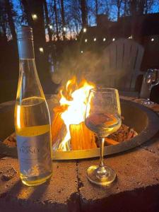 a bottle of wine and a glass on a table next to a fire at A Cozy Retreat in Gainesville