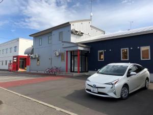 a white car parked in a parking lot in front of a building at Minshuku Cress - Vacation STAY 48568v in Biei