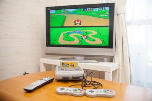 a television with two remote controls and a video game at Mansion Kitanomachi Room 408 - Vacation STAY 64438v in Awaji