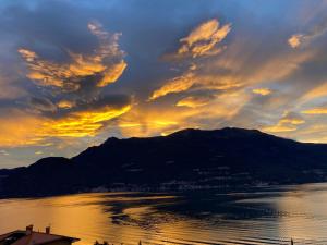 a sunset over the water with a mountain at ORO, 8 in Bellano