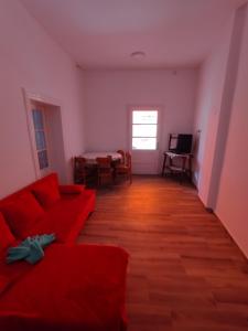 a living room with a red couch and a table at T.I.M. in Bela Crkva