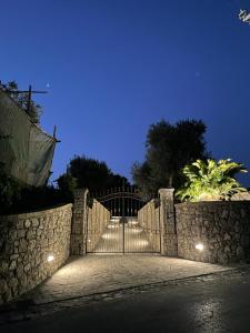 Una cerca de piedra con una puerta por la noche en Liparulo Holiday House, en Massa Lubrense