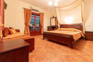 a bedroom with a bed and a couch at Pelagos Hotel in Agios Ioannis Pelio