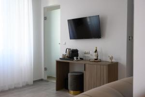 uma sala de estar com uma televisão na parede em AMALPHI Corfu City Living em Corfu Town
