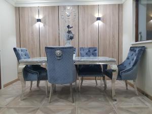 uma sala de jantar com uma mesa e cadeiras azuis em Elegant room In a private House em Rotherham