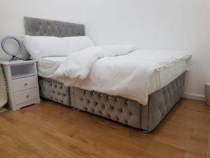 a bed in a room with a nightstand and a bed sidx sidx at Elegant room In a private House in Rotherham