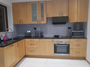 a kitchen with wooden cabinets and a stove top oven at Elegant room In a private House in Rotherham