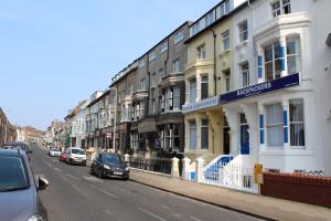 eine Straße mit Gebäuden und auf der Straße geparkten Autos in der Unterkunft Backpackers Blackpool Hotel & Suites in Blackpool