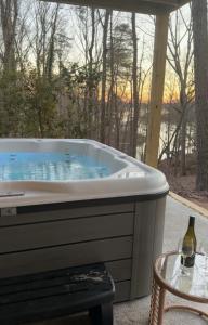 a hot tub with a table and a bottle of wine at A Cozy Retreat in Gainesville