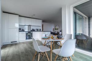 a kitchen with white cabinets and a table and chairs at Seaview West Coast in Bournemouth