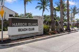 メルボルン・ビーチにあるVillatel at Harbor Island Beach Clubのヤシの木が植えられたビーチクラブの看板