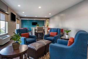 a waiting room with blue chairs and a table at Comfort Inn Indianapolis Airport in Plainfield